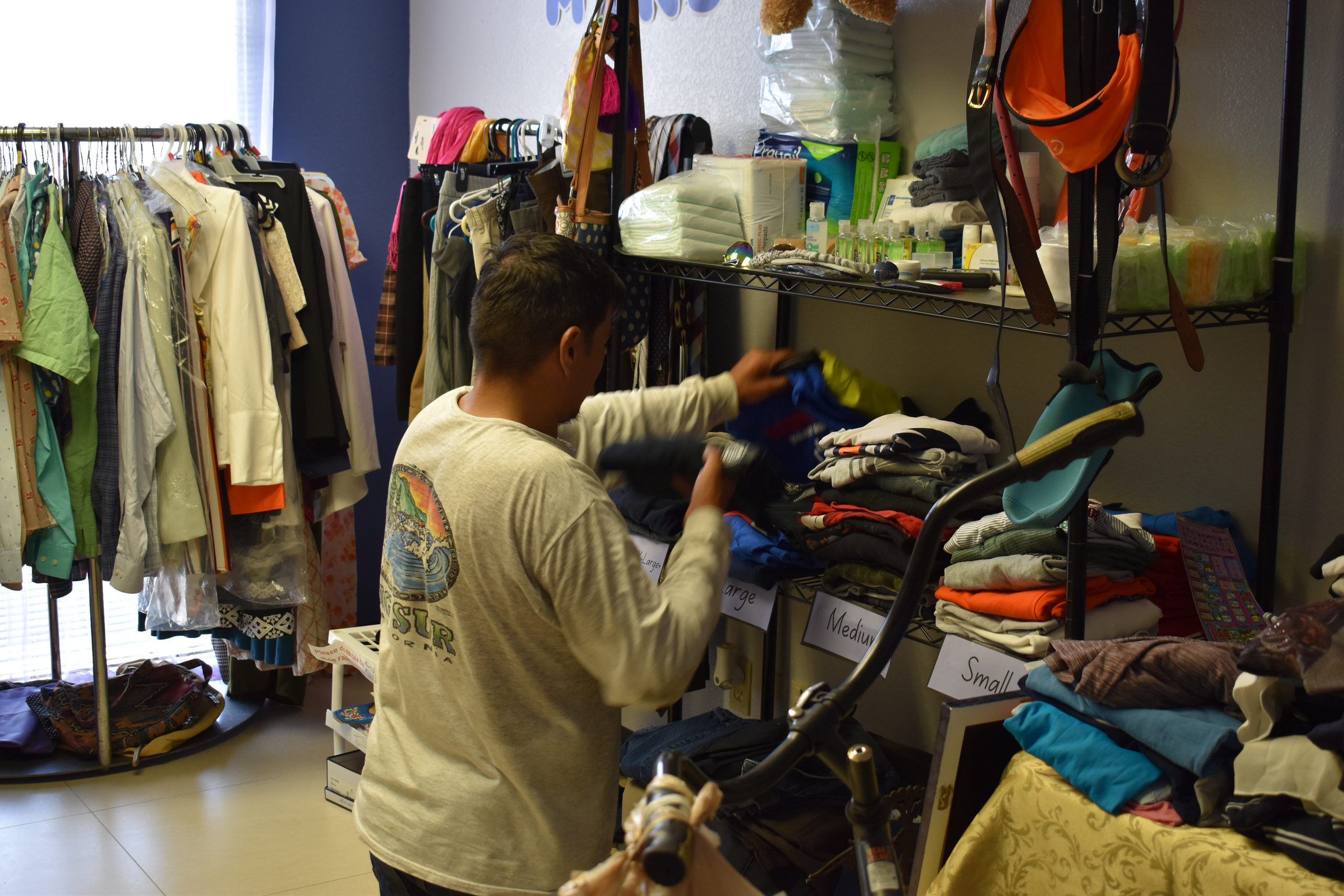 Una persona revisa ropa doblada en los estantes.