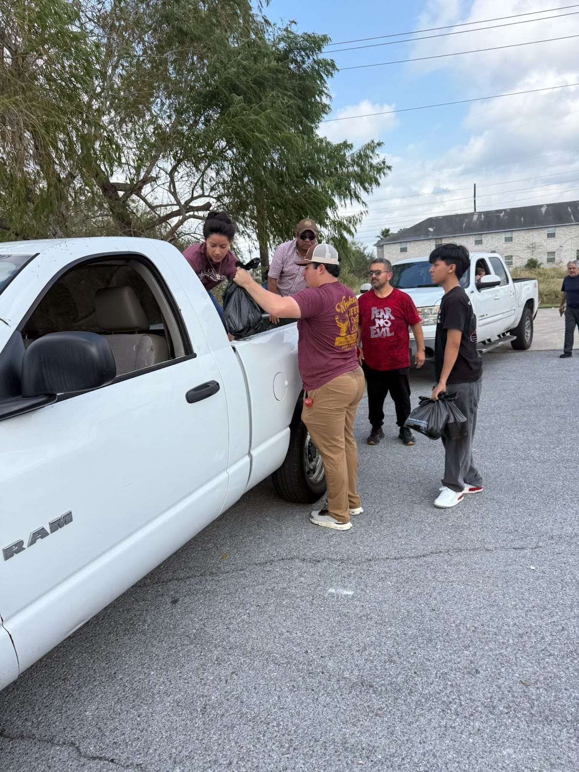 People load bags into a pickup truck.