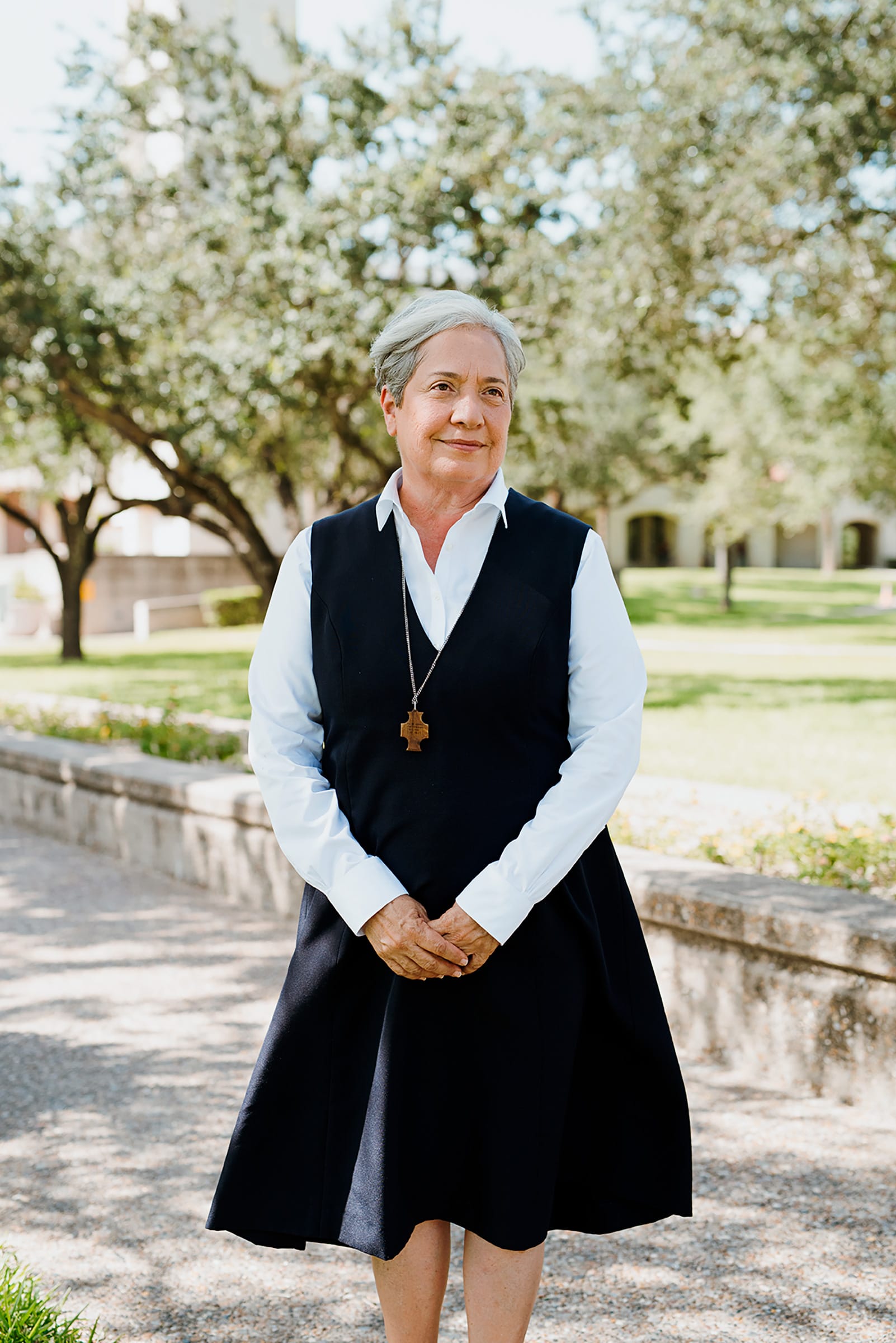 Sister Norma Pimentel standing outdoors on a tree-lined walkway.